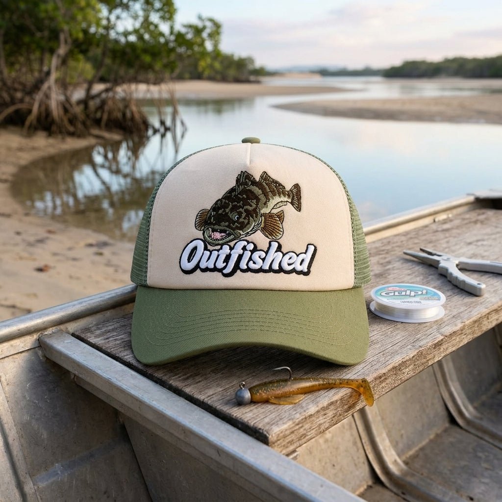 The Lizard flathead fishing cap on a tinny gunwale beside fishing rod